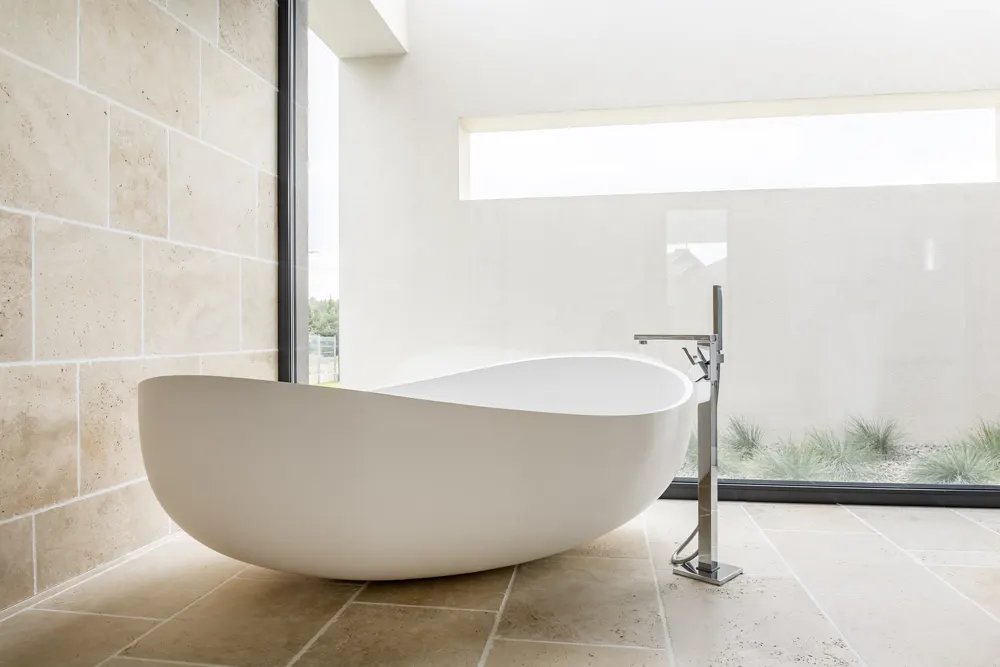 Freestanding tub against sealed ceramic tile walls