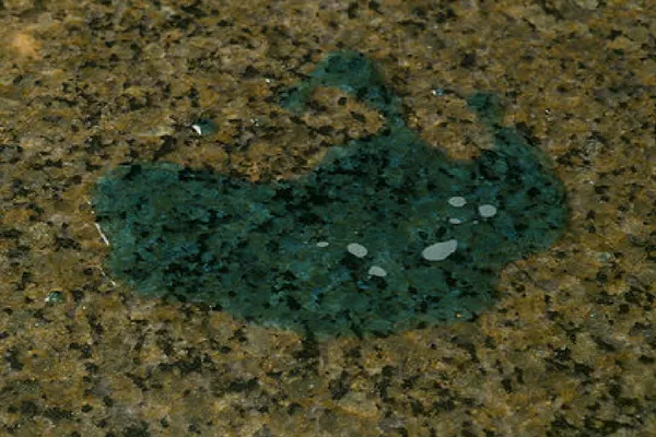 Untreated granite with blue dye pooling on the surface